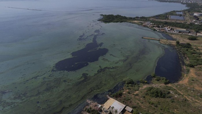 A boy walks between stilt houses, on the water's edge of Lake Maracaibo in the Santa Rosa de Agua neighborhood of Maracaibo, Venezuela, Tuesday, Aug. 8, 2023. The pollution around the lake, one of Latin America's largest, is the result of decades of excessive oil exploitation on its bed, inadequate maintenance, and a lack of investment to improve an already obsolete infrastructure, according to environmentalists. (AP Photo/Ariana Cubillos)