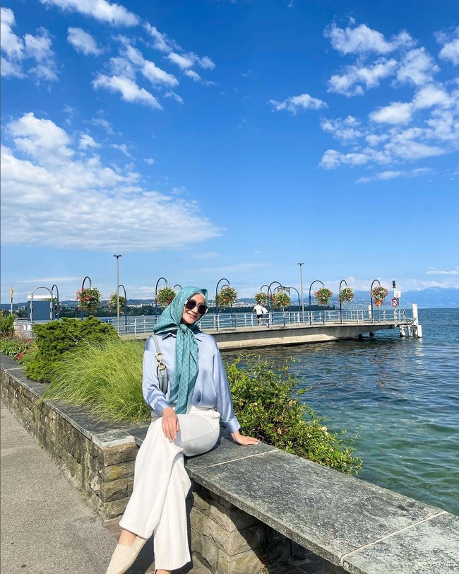 Kemeja satin dipadu celana panjang warna off-white memberi kesan elegan. Ayu memadukannya dengan scarf bermotif warna teal. Foto: Instagram/@ayumaulida97