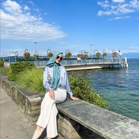 Kemeja satin dipadu celana panjang warna off-white memberi kesan elegan. Ayu memadukannya dengan scarf bermotif warna teal. Foto: Instagram/@ayumaulida97