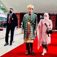 Penampilan Iriana Jokowi di sidang tahunan MPR 2022 berbeda dari tahun-tahun sebelumnya. Jika sebelumnya Iriana selalu hadir dengan rambut sanggul, kali ini istri Presiden Jokowi itu berhijab. Ibu Negara menggunakan kebaya warna pink dengan detail tile dan beads, dan selendang chiffon yang dihiasi aksen payet pada bagian bahu sebelah kanan. Wanita kelahiran 1 Oktober 1963 ini memakai hijab segi empat yang dilengkapi dengan inner hijab. Hijab dibentuk rapi dengan diikat rapi ke belakang. Foto: Dok. Detikcom, Biro Pers Setpres, Antara