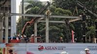 Tampak pekerja menyambung besi rangka untuk atap halte bus.  