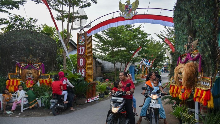 Warga melihat ornamen Reog Ponorogo di Desa Kolam, Percut Sei Tuan, Deli Serdang, Sumatera Utara, Selasa (15/8/2023). Dalam rangka memeriahkan HUT ke-78 RI, masyarakat setempat menghiasi seluruh gapura dengan berbagai ornamen unik seperti ornamen pesawat, Reog Ponorogo, kapal selam dan tank yang dilakukan secara swadaya. ANTARA FOTO/Fransisco Carolio/rwa.