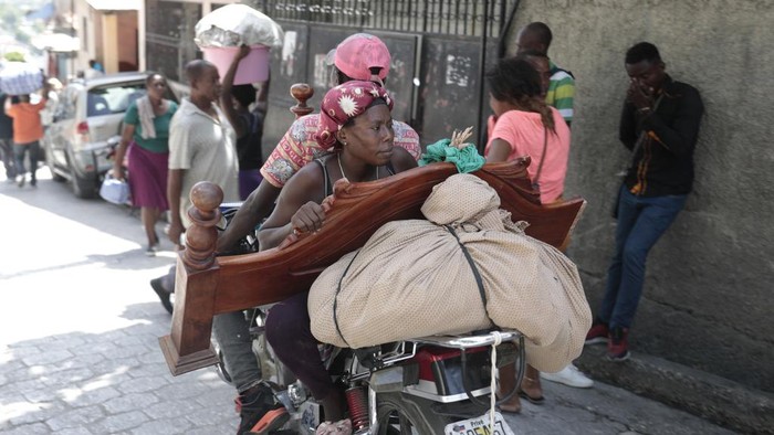 Warga Haiti Kabur dari Rumah Hindari Bentrok Geng Bersenjata Residents flee their homes to escape clashes between armed gangs in the Carrefour-Feuilles district of Port-au-Prince, Haiti, Tuesday, Aug. 15, 2023. (AP Photo/Odelyn Joseph)