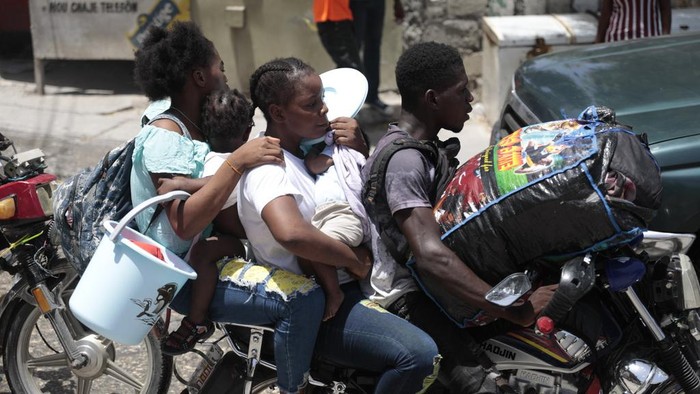 Residents flee their homes to escape clashes between armed gangs in the Carrefour-Feuilles district of Port-au-Prince, Haiti, Tuesday, Aug. 15, 2023. (AP Photo/Odelyn Joseph)