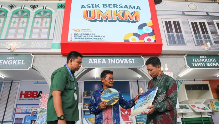 Pemilik UMKM binaan Astra melalui Yayasan Dharma Bhakti Astra (YDBA) dan PT United Tractors Tbk, Recycle Academi, Surani (tengah) saat menunjukkan lukisan yang dibuatnya dari limbah styrofoam kepada Dept. Head Training & Mentoring YDBA, Aloysius Daniel Harbianto (kiri) dan Pemilik UMKM binaan YDBA, PT Astana Wira Karya, Muhammad Umar Anif (kanan) dalam kegiatan #AsikBersamaUMKM YDBA di Pameran Gaikindo Indonesia International Auto Show (GIIAS) yang dilaksanakan di ICE BSD pada 10 – 20 Agustus 2023.