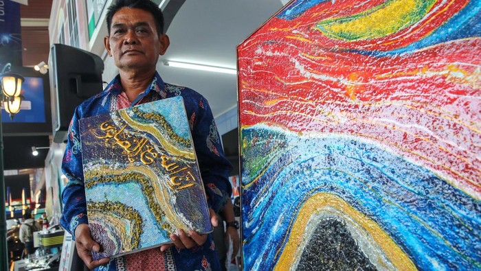 Asik Bersama UMKM YDBA di GIIAS 2023 Pemilik UMKM binaan Astra melalui Yayasan Dharma Bhakti Astra (YDBA) dan PT United Tractors Tbk, Recycle Academi, Surani (tengah) saat menunjukkan lukisan yang dibuatnya dari limbah styrofoam kepada Dept. Head Training & Mentoring YDBA, Aloysius Daniel Harbianto (kiri) dan Pemilik UMKM binaan YDBA, PT Astana Wira Karya, Muhammad Umar Anif (kanan) dalam kegiatan #AsikBersamaUMKM YDBA di Pameran Gaikindo Indonesia International Auto Show (GIIAS) yang dilaksanakan di ICE BSD pada 10 – 20 Agustus 2023.