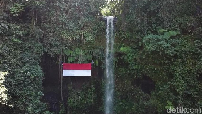 Bendera raksasa berkibar di Curug Gado Bangkong, Tasikmalaya, Kamis (17/8/2023).