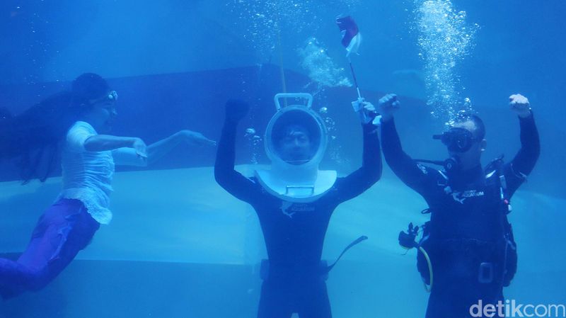 Penyelam mengibarkan bendera sepanjang 25 meter di dalam air di Jakarta Aquarium Safari, Jakarta Barat,  Kamis (17/8/2023). Pengibaran bendera ini dilakukan dalam peringatan HUT ke-78 Republik Indonesia.