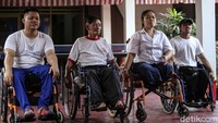 Empat penyandang disabilitas adu cepat dalam lomba balap kelereng.  