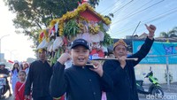 Ada juga warga yang membawa jempana berisikan makanan ringan, sayur hingga buah-buahan