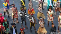 Peserta kirab tampak mengenakan pakaian adat dari berbagai daerah Indonesia. 
