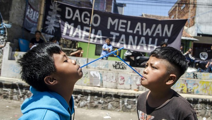 Anak-anak mengikuti lomba estafet karet dengan sedotan  di Dago Elos, Bandung, Jawa Barat, Kamis (17/8/2023). Warga melaksanakan sejumlah perlombaan bagi anak-anak untuk memperingati HUT ke-78 RI sekaligus mengembalikan keceriaan pascainsiden kericuhan beberapa waktu lalu di kawasan tersebut. ANTARA FOTO/Novrian Arbi/tom.