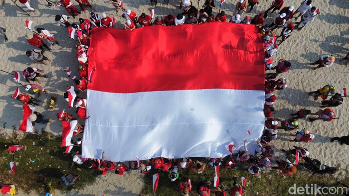 Ratusan pendayung dari Komunitas Dayung Jakarta mengibarkan bendera raksasa untuk memperingati HUT Ke-78 Republik Indonesia di Perairan Teluk Jakarta, Kamis (17/8/2023).