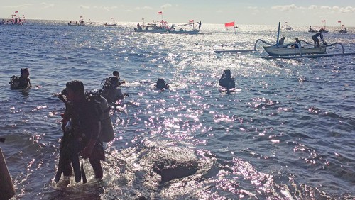 Para penyelam yang bertugas membentangkan bendera Merah Putih sepanjang 48 meter di bawah laut Pantai Tulamben, Karangasem, Bali, Kamis (17/8/2023).