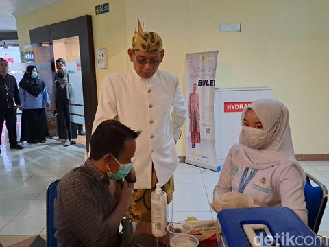 Pendaftaran dan masyarakat yang melakukan suntik pakai Vaksin Inavac di Gedung Rektorat Unair.