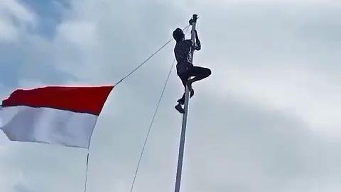Pria Cianjur naik tiang bendera.