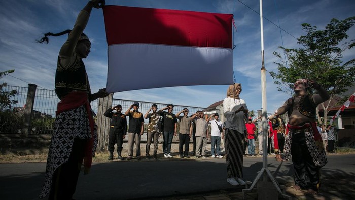 Warga berkostum tokoh punakawan membentangkan Bendera Merah Putih saat upacara peringatan HUT ke-78 Kemerdekaan RI di Kampung Banyuanyar, Solo, Jawa Tengah, Rabu (17/8/2023). Upacara yang diikuti 250 warga setempat itu untuk menanamkan semangat cinta tanah air. ANTARA FOTO/Mohammad Ayudha/tom.