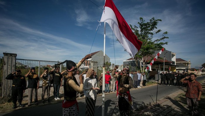 Warga berkostum tokoh punakawan membentangkan Bendera Merah Putih saat upacara peringatan HUT ke-78 Kemerdekaan RI di Kampung Banyuanyar, Solo, Jawa Tengah, Rabu (17/8/2023). Upacara yang diikuti 250 warga setempat itu untuk menanamkan semangat cinta tanah air. ANTARA FOTO/Mohammad Ayudha/tom.