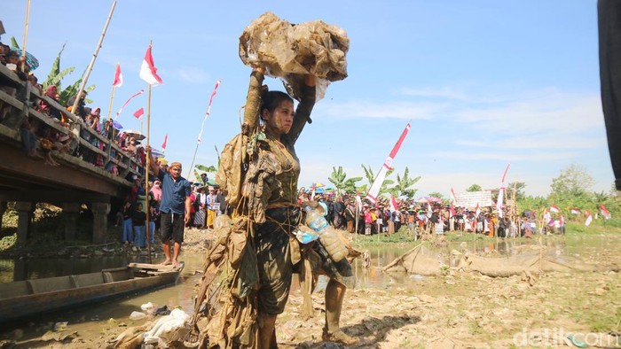 Warga yang tinggal di lereng Pegunungan Kendeng Kecamatan Sukolilo, Kabupaten Pati, Jawa Tengah menggelar upacara rakyat di gundukan sampah sungai Kali Tus, kamis(17/8/2023).