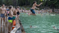 Sebagian warga memilih berenang di danau untuk mendinginkan diri.  