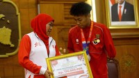 Gubernur Jawa Timur Khofifah Indar Parawansa menyerahkan penghargaan dan bonus kepada atlet paragames Firza Faturahman Listianto di Gedung Negara Grahadi, Surabaya, Jumat (18/8/2023).  