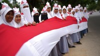Sebanyak 17 ribu siswa SMA dan SMK di Kendari membentangkan Bendera Merah Putih sepanjang 17 kilometer di Jalan Poros penghubung antara Teluk Kendari hingga perbatasan Kabupaten Konawe Selatan, Kamis (17/8/2023). ANTARA FOTO/Jojon