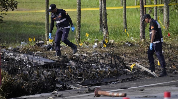 A member of the fire and rescue department inspect the crash site of a small plane in Shah Alam district, Malaysia, Thursday, Aug. 17, 2023. Police say a small aircraft has crashed in the suburb of Malaysias central Selangor state, with multiple bodies recovered. (AP Photo/Vincent Thian)