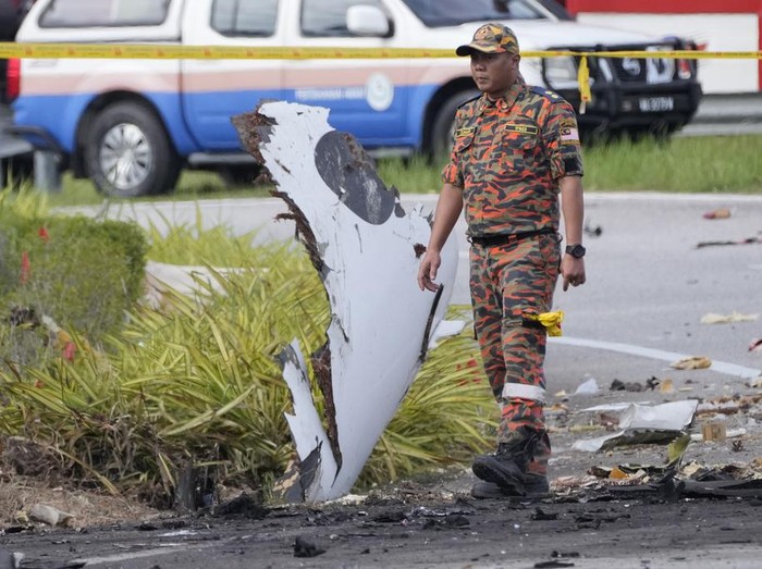 A member of the fire and rescue department inspect the crash site of a small plane in Shah Alam district, Malaysia, Thursday, Aug. 17, 2023. Police say a small aircraft has crashed in the suburb of Malaysias central Selangor state, with multiple bodies recovered. (AP Photo/Vincent Thian)