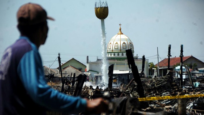Helikopter Water Boombing Coba Padamkan Kebakaran Kapal di Tegal Helikopter water boombing menyemprotkan air di lokasi kebakaran kapal di Pelabuhan Jongor, Tegal, Jawa Tengah, Jumat (18/8/2023). Badan Nasional Penanggulangan Bencana (BNPB) pada hari keempat kembali mengerahkan helikopter water boombing untuk melakukan pemadaman kapal nelayan yang masih mengeluarkan asap. ANTARA FOTO/Oky Lukmansyah/rwa.