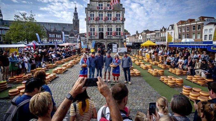 Kemeriahan Pasar Keju Gouda di Belanda yang Mendunia A young woman wears a traditional dress as she displays a loaf of Gouda cheese at the cheese market in Gouda, Netherlands, Thursday, Aug. 17, 2023. The cheese market takes place very Thursday and has a 900-year-old tradition. (AP Photo/Michael Probst)