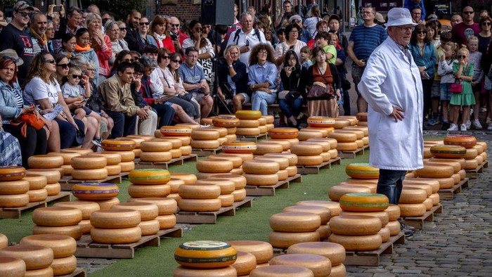 Kemeriahan Pasar Keju Gouda di Belanda yang Mendunia A young woman wears a traditional dress as she displays a loaf of Gouda cheese at the cheese market in Gouda, Netherlands, Thursday, Aug. 17, 2023. The cheese market takes place very Thursday and has a 900-year-old tradition. (AP Photo/Michael Probst)