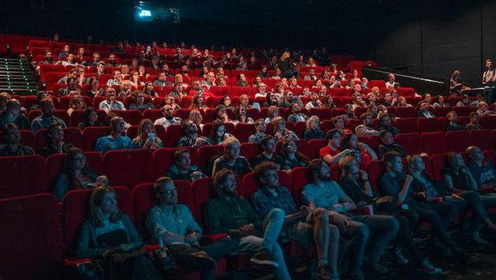 Menonton film di bioskop.