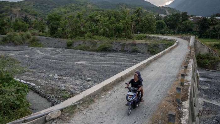 Penurunan debit air di cekdam Balane Pengendara sepeda motor melintas di atas cekdam Balane di Desa Balane, Sigi, Sulawesi Tengah, Jumat (18/8/2023). Cekdam yang selain berfungsi sebagai pengendali banjir, juga sebagai sumber air baku bagi warga sekitar dan pengairan bagi lahan pertanian itu mengalami penurunan debit air yang signifikan sejak sebulan terakhir akibat kemarau. ANTARA FOTO/Basri Marzuki/tom.