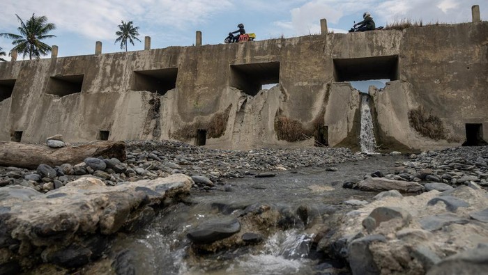 Pengendara sepeda motor melintas di atas cekdam Balane di Desa Balane, Sigi, Sulawesi Tengah, Jumat (18/8/2023). Cekdam yang selain berfungsi sebagai pengendali banjir, juga sebagai sumber air baku bagi warga sekitar dan pengairan bagi lahan pertanian itu mengalami penurunan debit air yang signifikan sejak sebulan terakhir akibat kemarau. ANTARA FOTO/Basri Marzuki/tom.