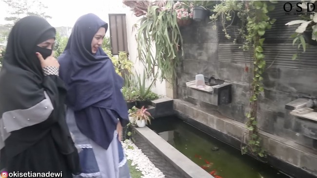 Sebuah kolam ikan yang dipermanis dengan tanaman hias menyambut tamu di halaman depan. (Foto: YouTube/Oki Setiana Dewi)