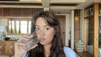 Aurelie Moeremans pun tampil menawan saat minum segelas air putih. Foto: Instagram @aurelie