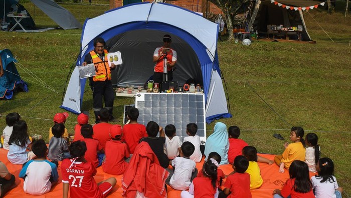 Aktivis Hafiz Riza (kanan) menyampaikan penjelasan tentang energi terbarukan saat acara 'Camping Kemerdekaan' di kawasan perkemahan Batu Kembar, Caringin, Kabupaten Bogor, Jawa Barat, Sabtu (19/8/2023). Kegiatan yang digelar komunitas Camping Adventure Family Indonesia bekerja sama dengan komunitas I Love Energi Surya tersebut bertujuan untuk mengedukasi pentingnya energi bersih yang ramah lingkungan sekaligus untuk memeriahkan HUT ke-78 kemerdekaan Republik Indonesia. ANTARA FOTO/Aditya Pradana Putra/foc.