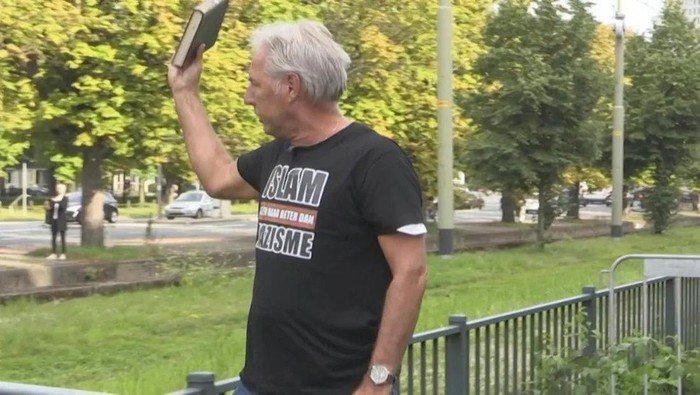 Leader of the Dutch chapter of the far-right Pegida group Edwin Wagensveld tears pages from the Quran in front of the Turkish embassy in The Hague, Netherlands on August 19, 2023. (AFP)