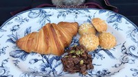 Kalau ini pose Popeye ketika menikmati croissant dan camilan diatas piring biru. Senyuman dan lirikan matanya sungguh menggemaskan! Foto: Instagram @popeyethefoodie