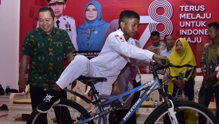 Siswa SMA bernama Rizki Lamato (14) di Kabupaten Gorontalo Utara yang memanjat tiang bendera saat upacara HUT ke-78 RI mendapat hadiah sepeda dari Pj Gubernur Gorontalo Ismail Pakaya.
