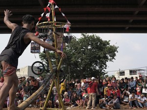 Pegadaian Gelar Lomba Panjat Pinang Berhadiah Emas di Aliran Kalimalang