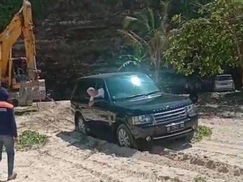 Mobil hitam terjebak di pasir Pantai Timbis ditarik eskavator, Sabtu (19/8/2023). (Foto: Istimewa)