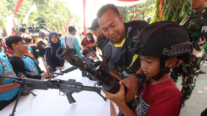Pameran alutsista di Kota Kediri Seorang pelajar memegang senjata didampingi prajurit TNI AD saat pameran alutsista di Kota Kediri, Jawa Timur, Sabtu (19/8/2023). Pameran yang mengundang pelajar tingkat SD hingga SMP se-Kota Kediri tersebut bertujuan untuk mengenalkan berbagai alutsista milik TNI AD kepada pelajar sekaligus guna memperingati HUT ke-78 Kemerdekaan RI. ANTARA FOTO/Prasetia Fauzani/foc.