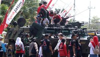 Sejumlah pelajar menaiki kendaraan tempur tipe Anoa pada pameran alutsista di Kota Kediri, Jawa Timur, Sabtu (19/8/2023).  