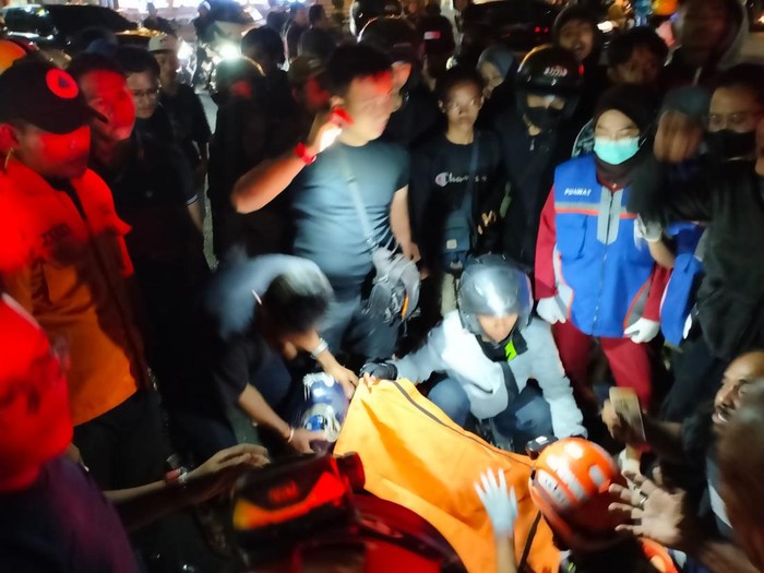 Petugas saat mengevakuasi korban tewas terlindas truk di Surabaya