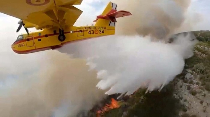 Potret Helikopter Bolak-balik Padamkan Api di Pulau Tenerife A firefighter plane discharges water over a forest fire in La Esperanza on the island of Tenerife, Canary Islands, Spain August 17, 2023. REUTERS/Borja Suarez