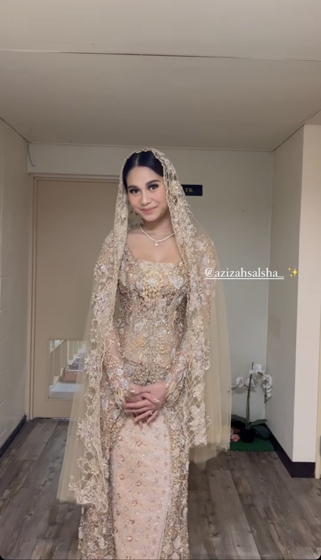 Kebaya berpotongan panjang menyapu lantai itu karya desainer Asky Febrianti. Saat akad nikah, Anisa tampil semakin menawan dengan kerudung panjang yang senada. Foto: dok. Instagram/@ochiipramita