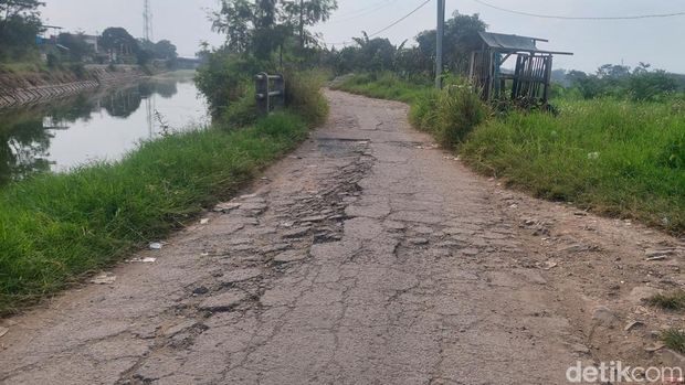 Kondisi jalan sempadan Sungai Cikeruh, Bojongsoang yang rusak