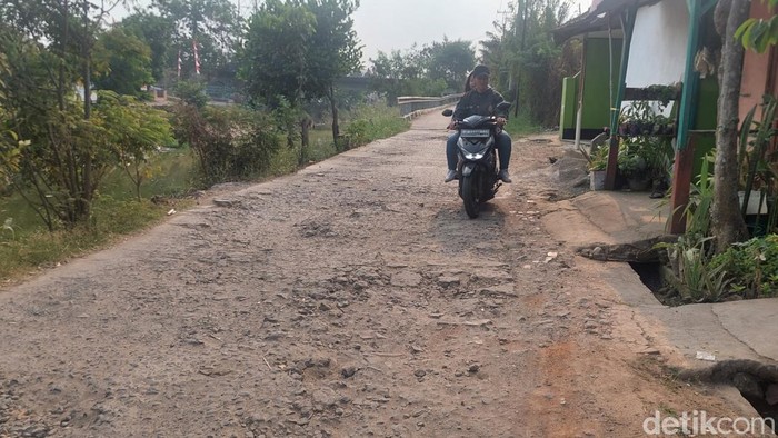 Kondisi jalan sempadan Sungai Cikeruh, Bojongsoang yang rusak