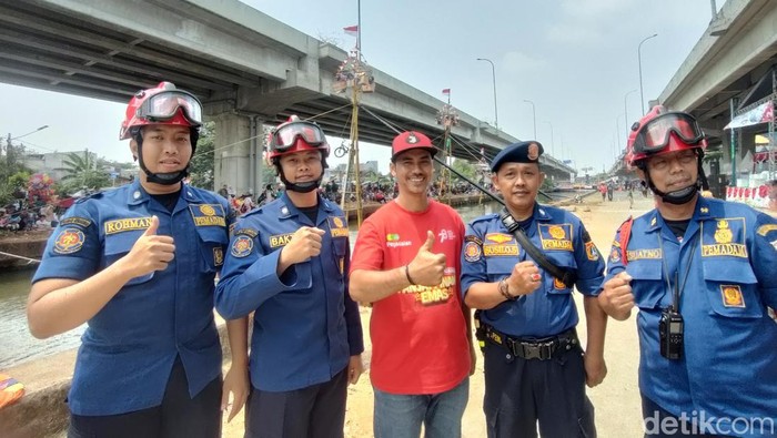 Petugas damkar bersiaga di lokasi lomba panjat pinang.